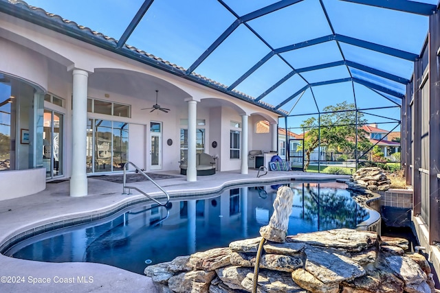 view of pool featuring a patio area, ceiling fan, and glass enclosure