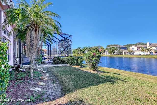 view of yard featuring a water view and glass enclosure