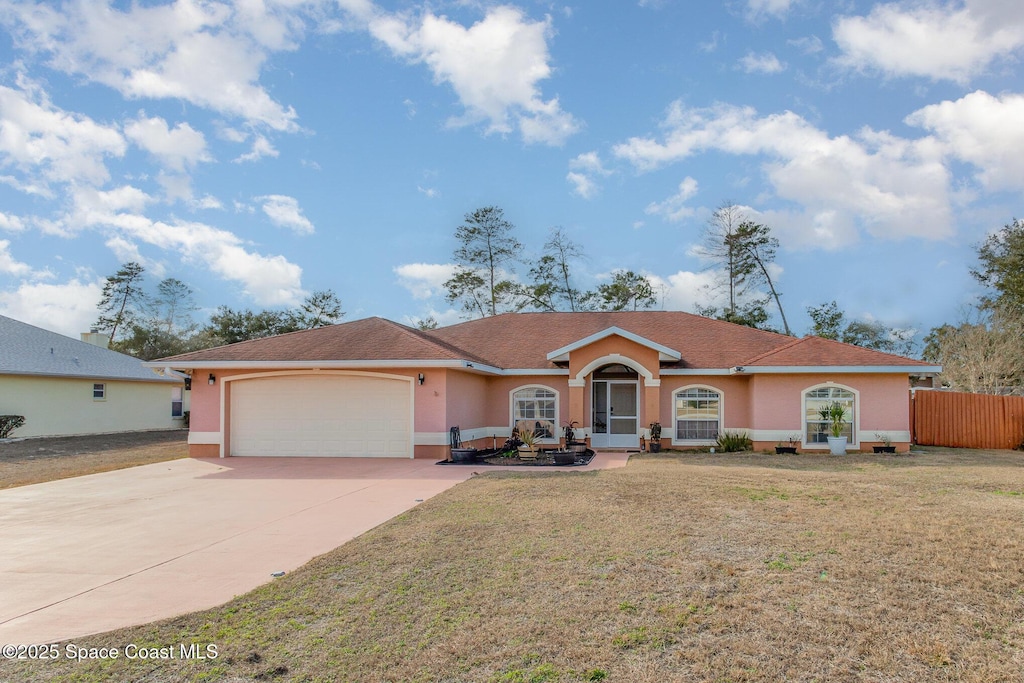 single story home with a garage and a front lawn