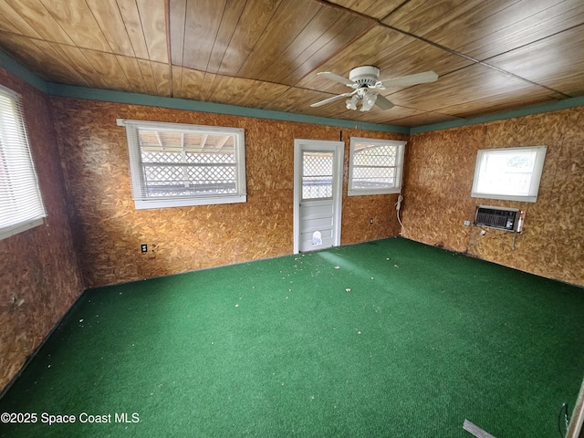 carpeted empty room featuring ceiling fan, heating unit, and wood ceiling