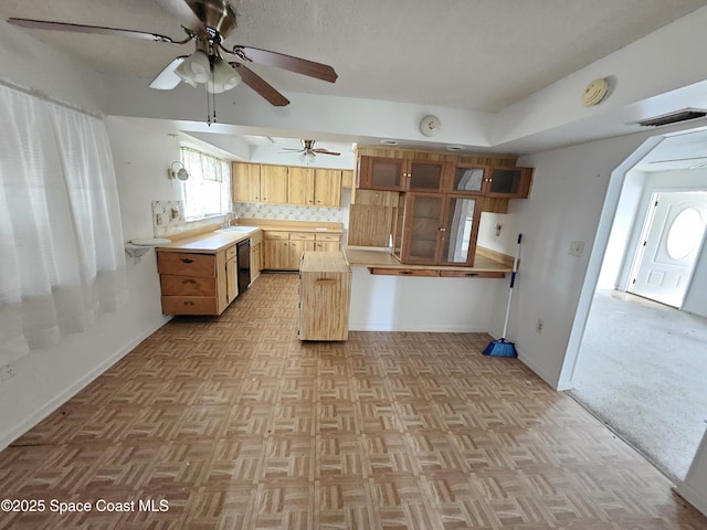 kitchen featuring sink, light parquet floors, dishwasher, ceiling fan, and tasteful backsplash