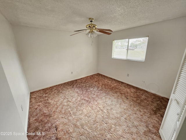 empty room with ceiling fan, a textured ceiling, and carpet flooring