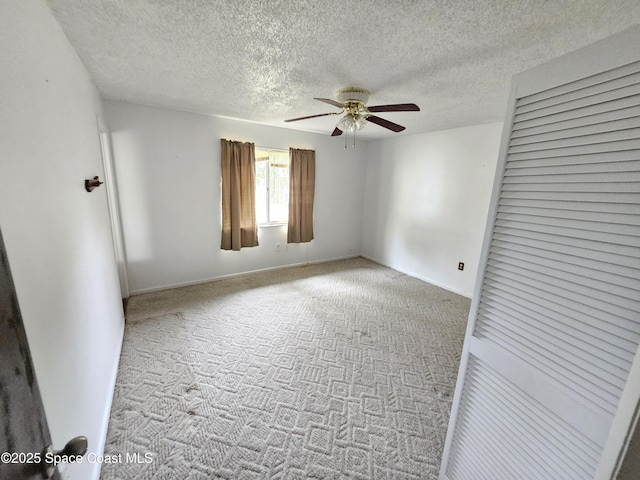 empty room with carpet floors, a textured ceiling, and ceiling fan