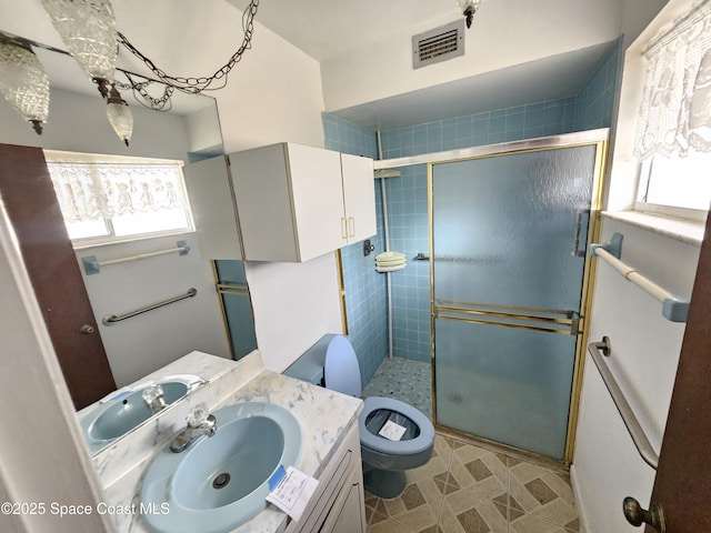 bathroom with vanity, a shower with door, and toilet