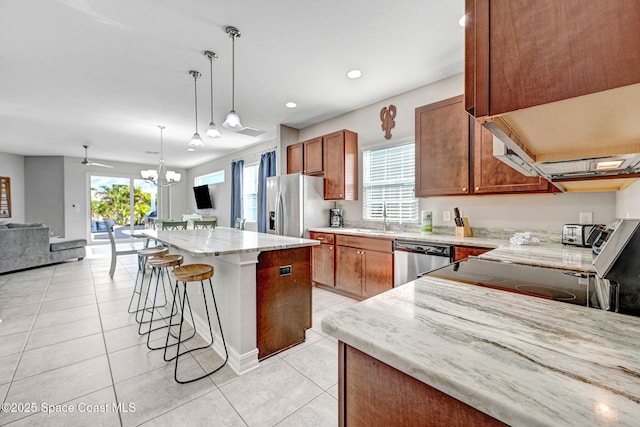 kitchen featuring pendant lighting, light tile patterned floors, sink, stainless steel appliances, and a kitchen island