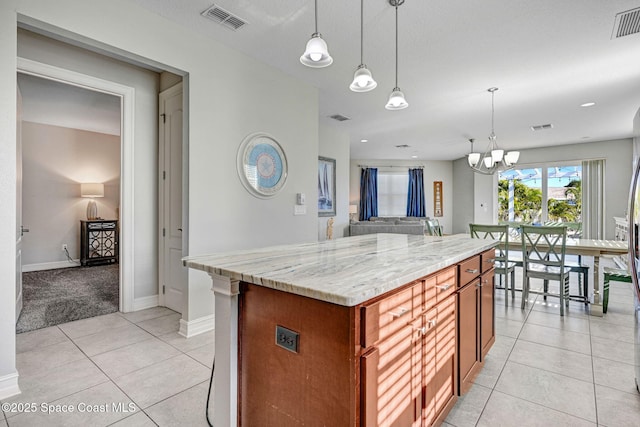 kitchen featuring hanging light fixtures, light tile patterned flooring, a center island, and a notable chandelier