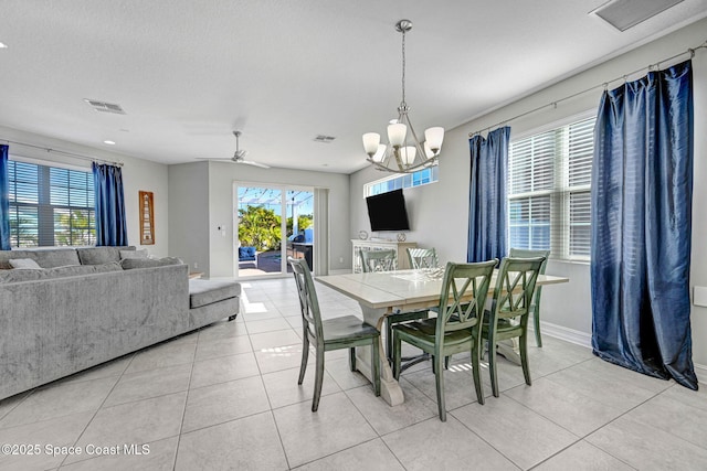 tiled dining space featuring an inviting chandelier and a textured ceiling