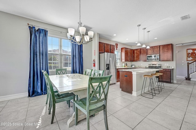 dining area with a healthy amount of sunlight, light tile patterned floors, and an inviting chandelier