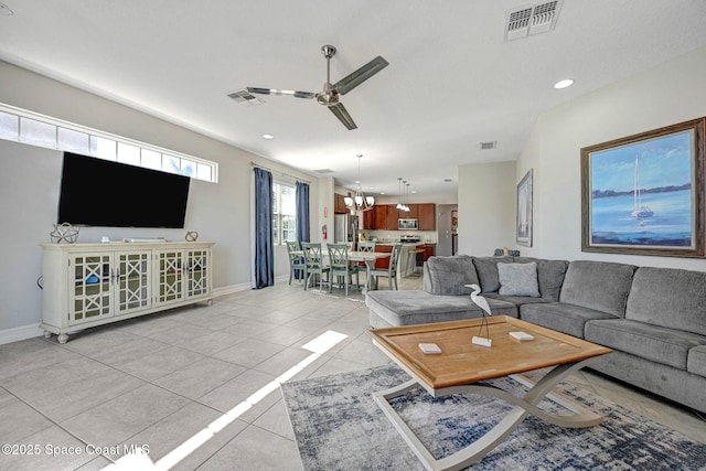 living room featuring light tile patterned floors and ceiling fan with notable chandelier