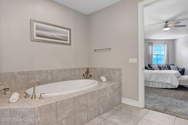 bathroom with ceiling fan, tile patterned flooring, and tiled tub