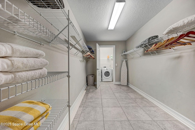 spacious closet featuring washer / dryer and tile patterned floors