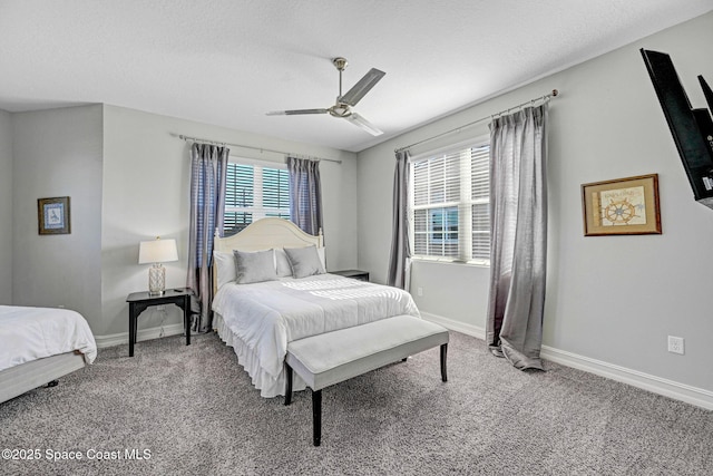 carpeted bedroom featuring ceiling fan and a textured ceiling