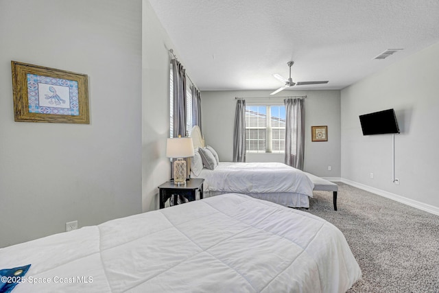 carpeted bedroom featuring ceiling fan and a textured ceiling