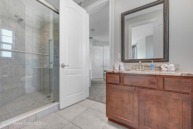 bathroom featuring vanity, tile patterned flooring, and a shower with door