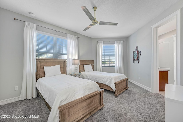 carpeted bedroom with ceiling fan and a textured ceiling