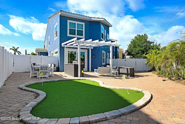 rear view of house featuring a pergola and a patio area