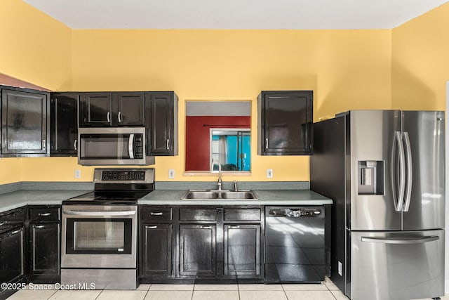 kitchen with sink, stainless steel appliances, and light tile patterned flooring