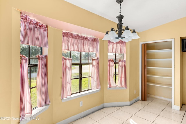 unfurnished dining area with an inviting chandelier and light tile patterned flooring