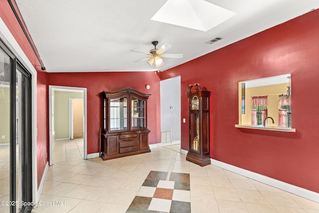 hallway featuring light tile patterned floors and a skylight