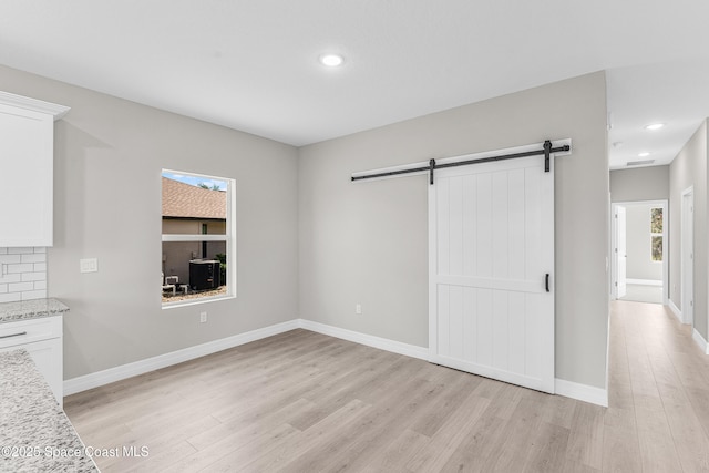 interior space featuring light hardwood / wood-style floors and a barn door