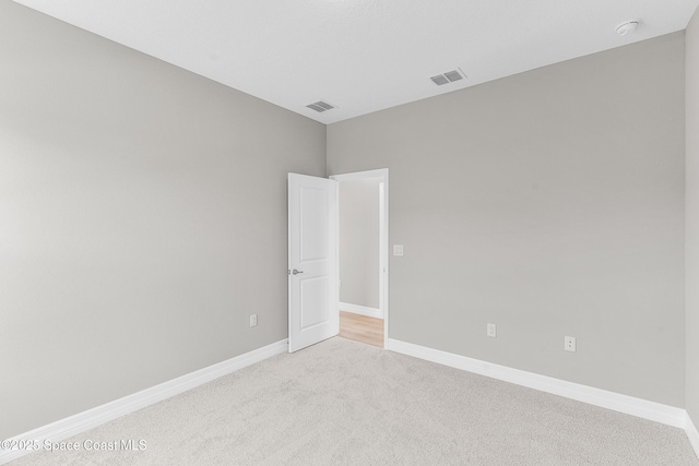 unfurnished room featuring light carpet