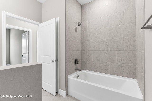 bathroom with tiled shower / bath combo and tile patterned flooring