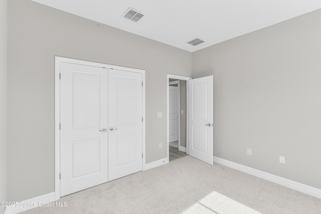 unfurnished bedroom with a closet and light carpet