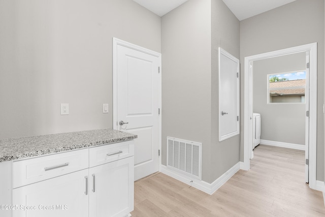 hallway featuring washer / clothes dryer and light wood-type flooring