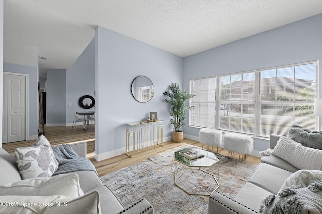 living room with plenty of natural light, hardwood / wood-style floors, and a textured ceiling