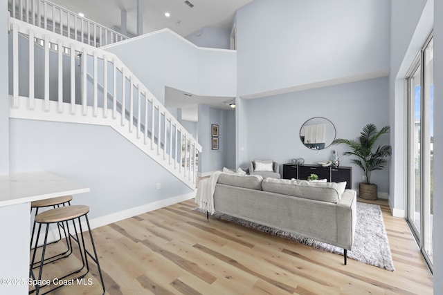 living room with light hardwood / wood-style flooring and a high ceiling