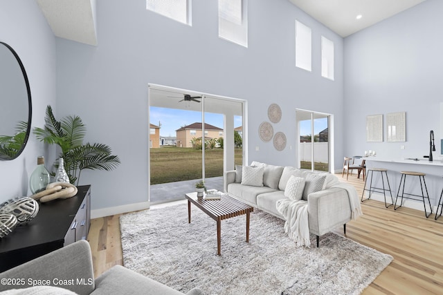 living room featuring a high ceiling and light hardwood / wood-style flooring