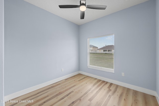 spare room with ceiling fan, a textured ceiling, and light wood-type flooring