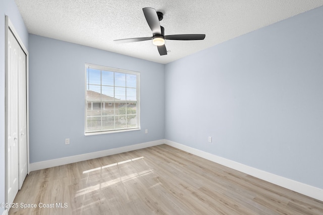 interior space featuring ceiling fan, a textured ceiling, light wood-type flooring, and a closet