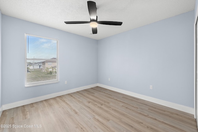 empty room featuring ceiling fan, a textured ceiling, and light wood-type flooring