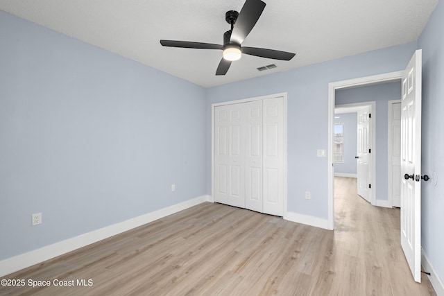 unfurnished bedroom featuring light hardwood / wood-style flooring, a closet, and ceiling fan