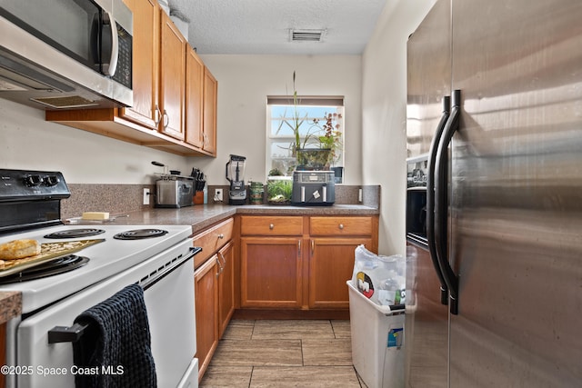 kitchen with appliances with stainless steel finishes and a textured ceiling