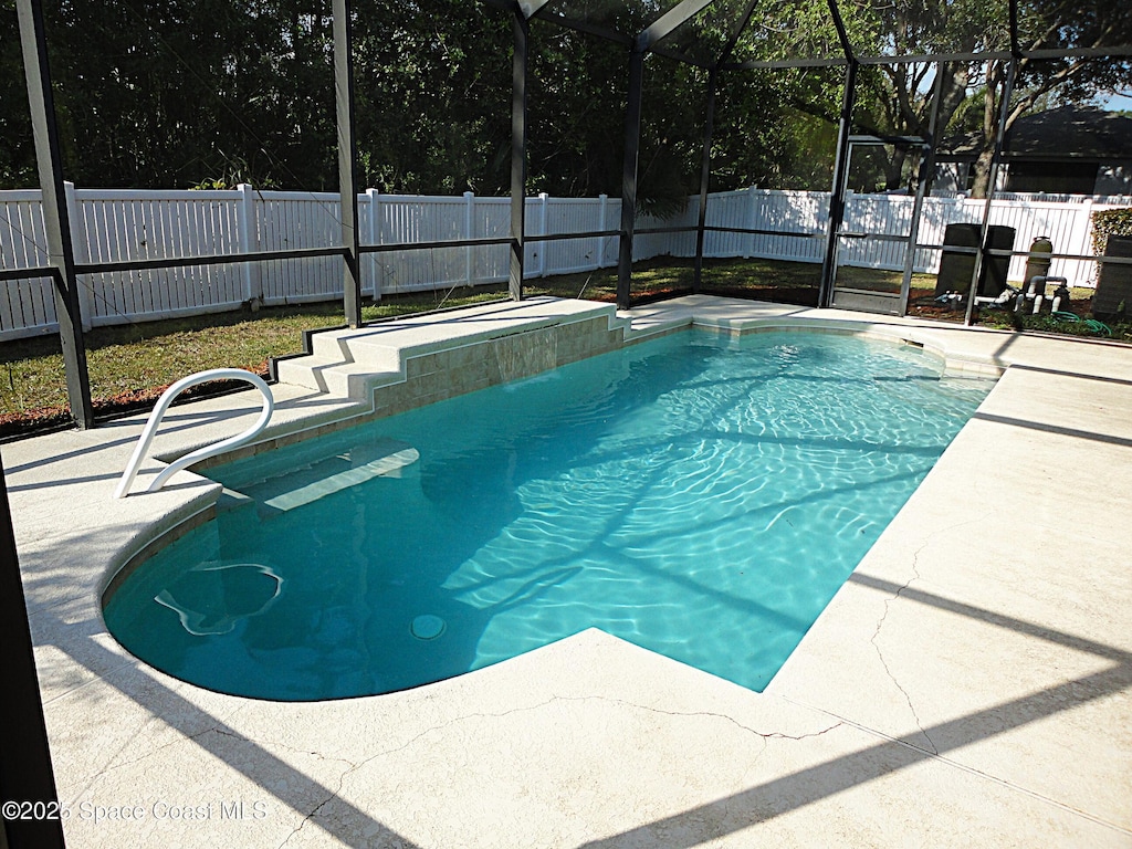 view of pool featuring a patio area and glass enclosure