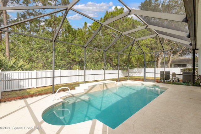 view of pool with glass enclosure, a patio area, a fenced backyard, and a fenced in pool