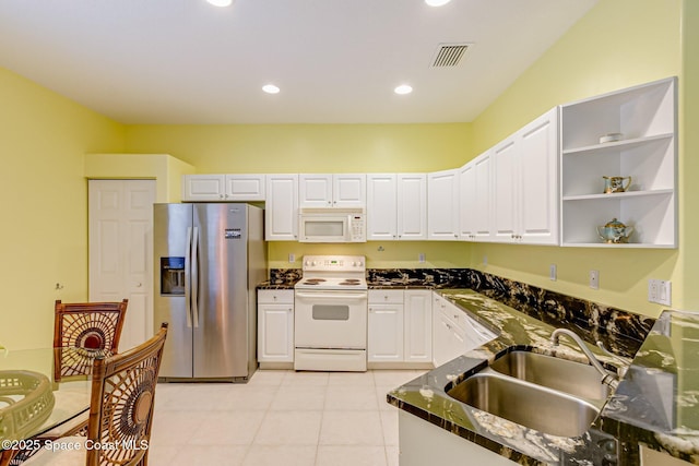 kitchen with visible vents, a sink, white cabinetry, recessed lighting, and white appliances