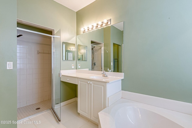 bathroom featuring vanity, a shower stall, a garden tub, and tile patterned floors