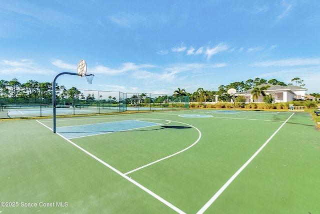 view of basketball court featuring a tennis court, community basketball court, and fence