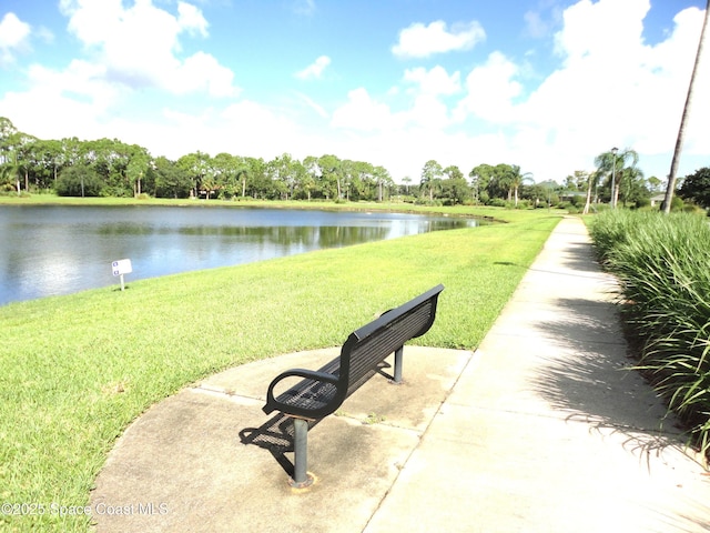 view of property's community featuring a lawn and a water view