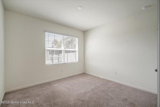 empty room featuring carpet floors and a textured ceiling