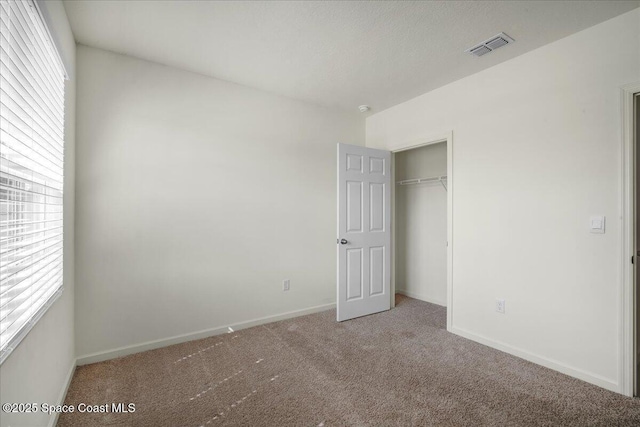 unfurnished bedroom featuring carpet floors and a closet