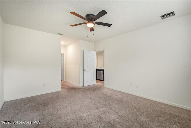 unfurnished room with ceiling fan, light carpet, and a textured ceiling