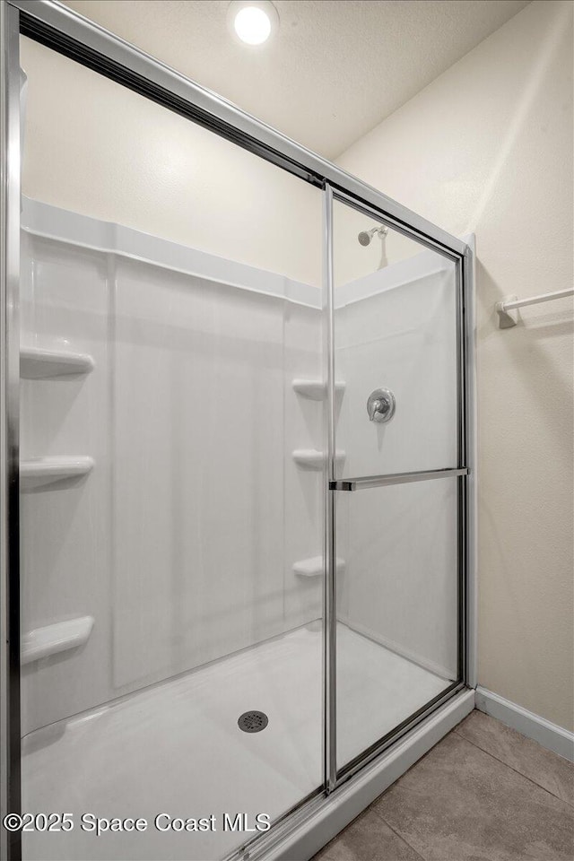 bathroom with tile patterned flooring and a shower with door