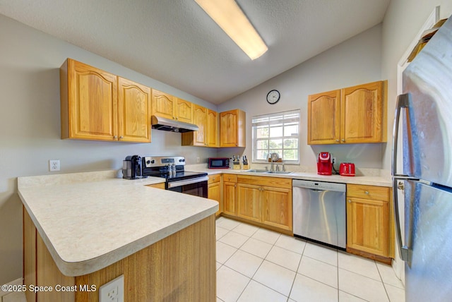 kitchen featuring lofted ceiling, sink, light tile patterned floors, kitchen peninsula, and stainless steel appliances