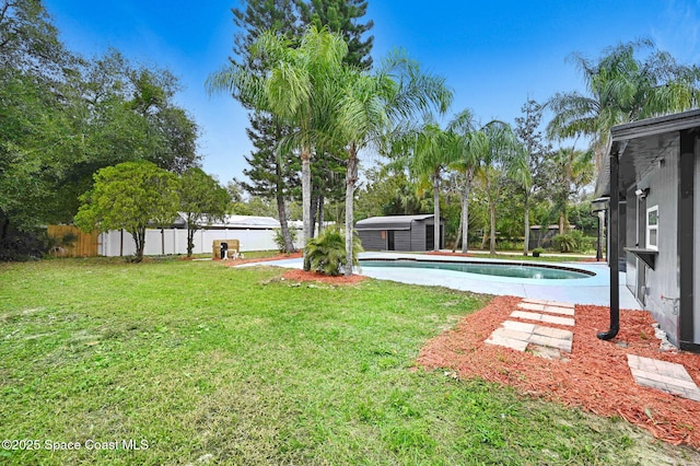 view of yard featuring a shed and a fenced in pool