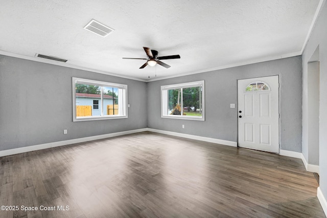 interior space with ceiling fan, ornamental molding, dark hardwood / wood-style floors, and a textured ceiling