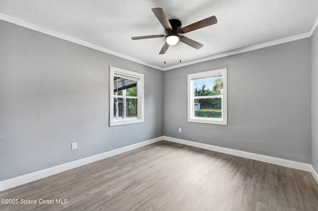 empty room with hardwood / wood-style flooring, ornamental molding, and ceiling fan